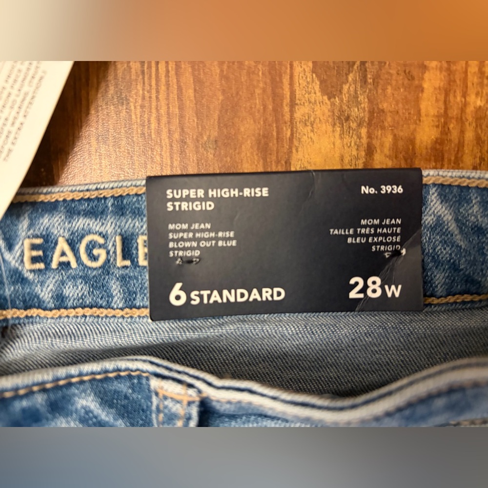 American Eagle Strigid Ripped Mom Jeans in a color-blown-out blue shade.